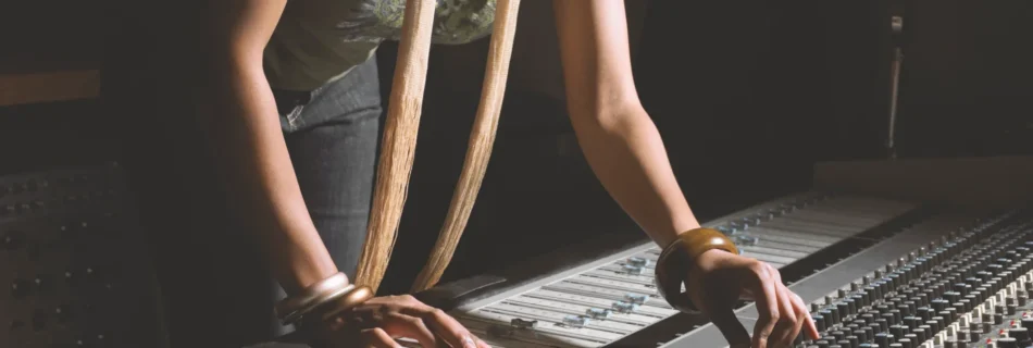 Ingénieure du son ajustant une table de mixage dans un studio d'enregistrement.