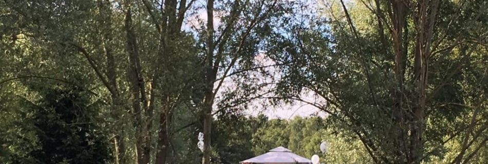 Cérémonie de mariage en plein air au bord d'un lac, entourée de nature et d'arbres.