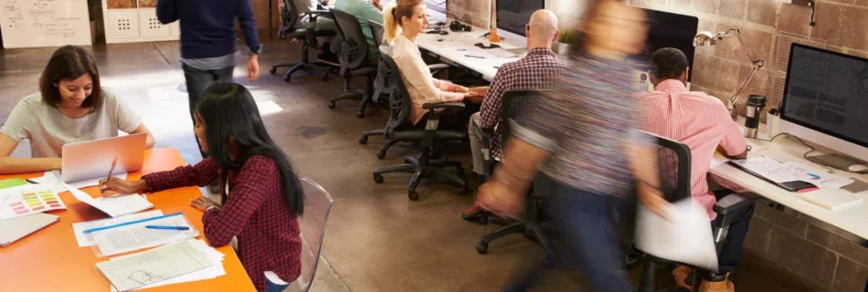 Un espace de coworking moderne avec des professionnels travaillant à leurs bureaux et en collaboration.