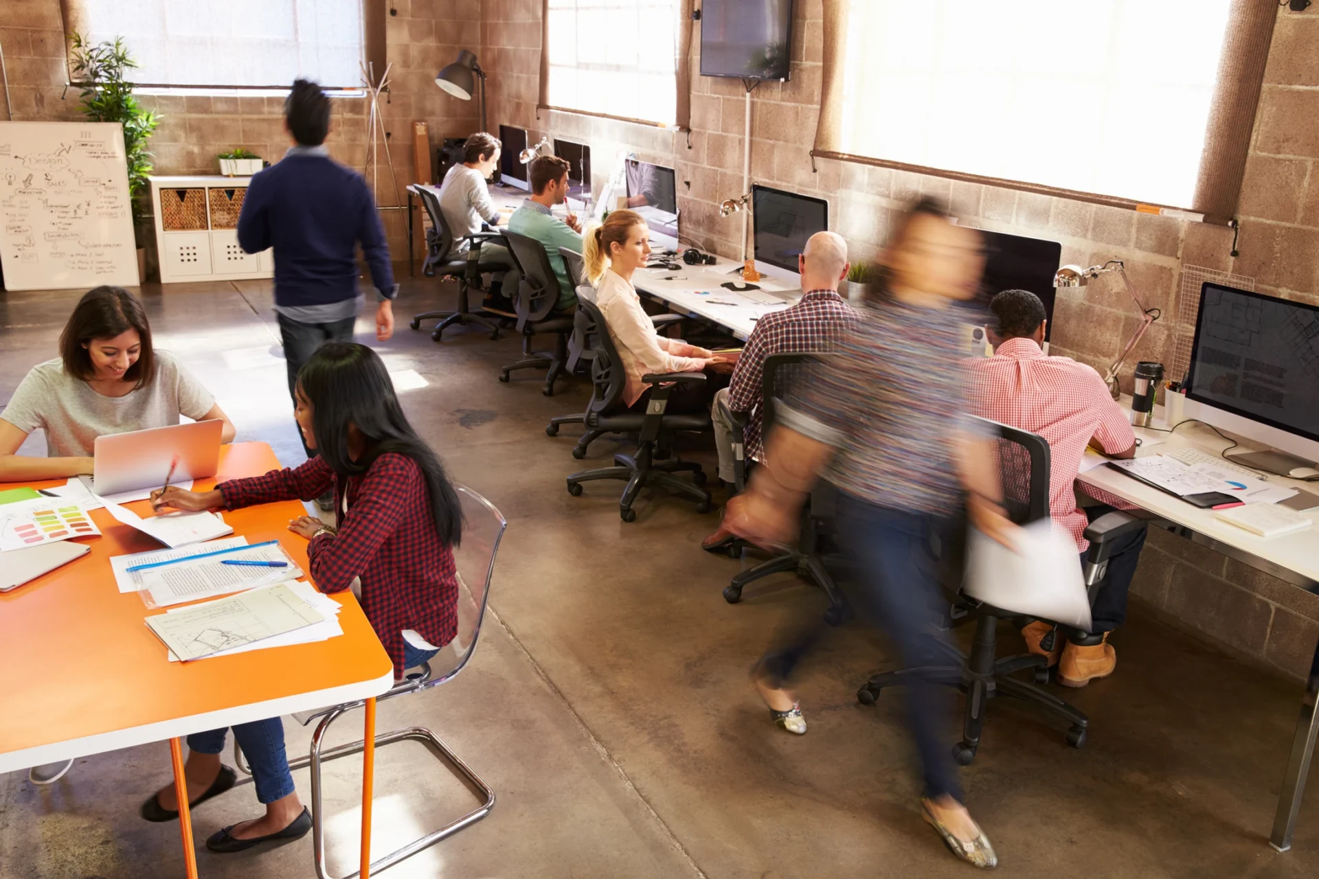 Un espace de coworking moderne avec des professionnels travaillant à leurs bureaux et en collaboration.